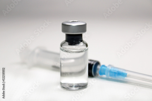 Syringe and a bottle of medicine close-up on a light background. Blurred background