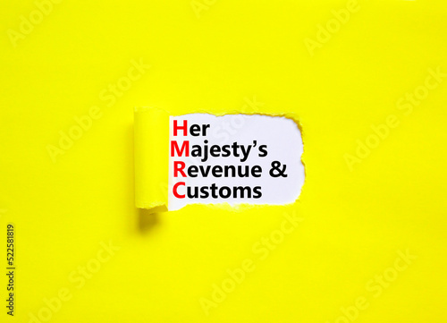 HMRC her majestys revenue and customs symbol. Concept words HMRC her majestys revenue and customs on white paper on beautiful yellow background. Business HMRC revenue and customs concept. Copy space. photo