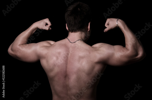 Muscular man posing in the studio isolated on black background