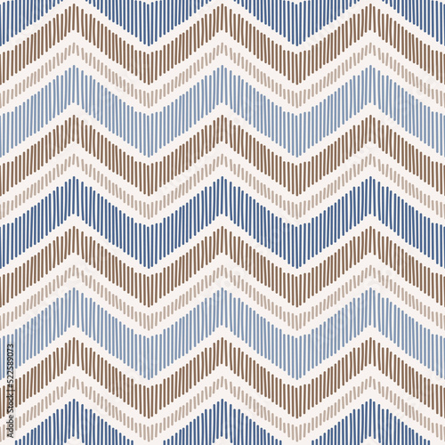 Seamless pattern with hand drawn chevron design. Modern ikat print with blue and brown stripes.