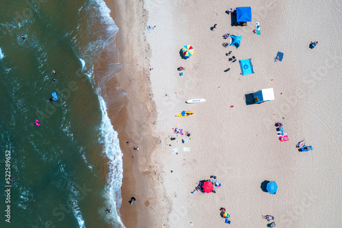 Aerial view of a lifeguard stand and a rescue board on a beach with umbrellas