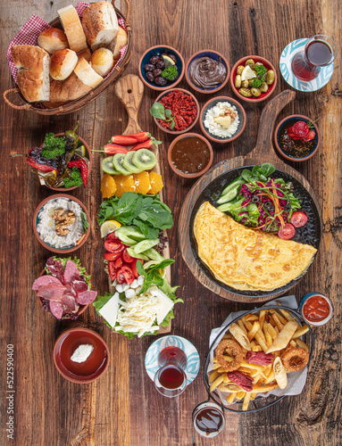 Traditional Turkish Breakfast served with traditional turkish tea on wood table. Breakfast or brunch table filled with all sorts of delicious delicatessen. Turkish name; Serpme Kahvalti.