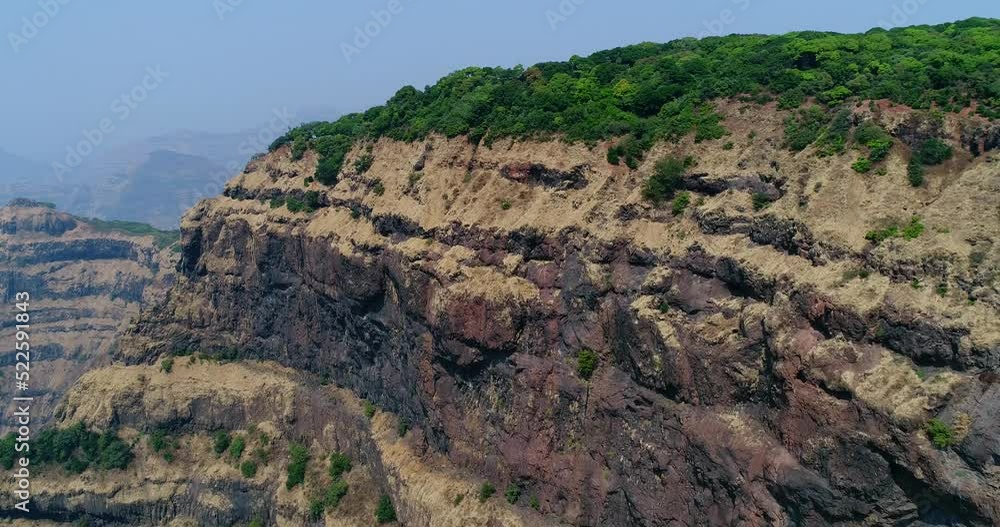 Aerial shot of steep cliffs with stair shape and tropical vegetation on top Aerial shot of steep cliffs with stair shape and tropical vegetation on top
