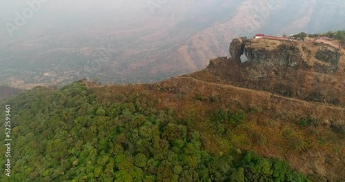 Aerial shot of steep rocky hill with tropical vegetation and view point photo