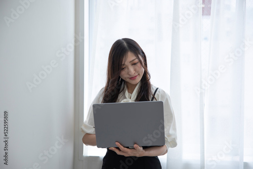 A working Japanese woman by remote work in the home office closeup