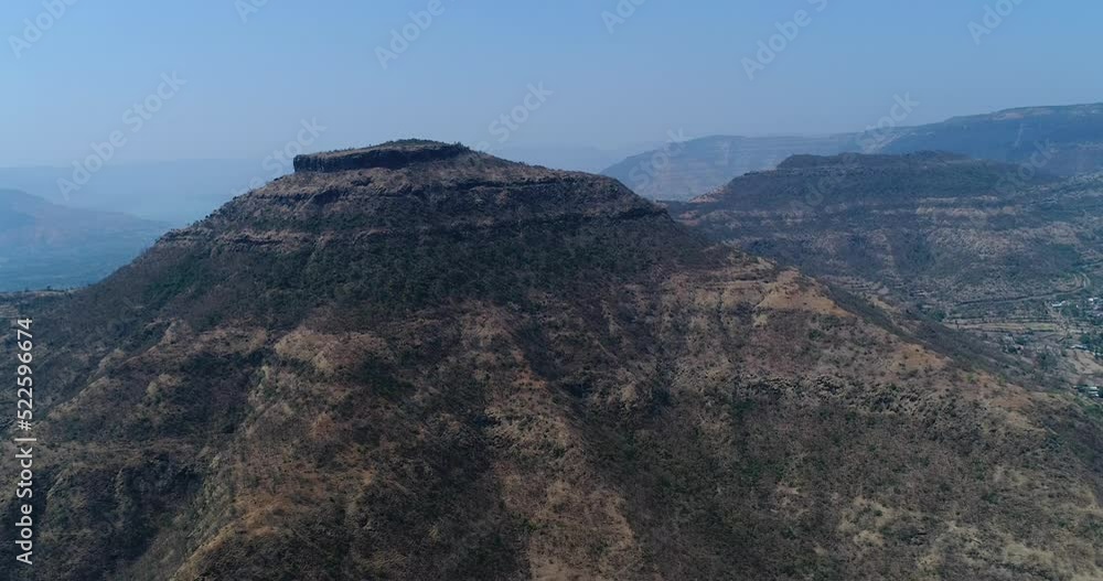 Aerial shot of steep rocky hill with dry vegetation on it Aerial shot of steep rocky hill with dry vegetation on it