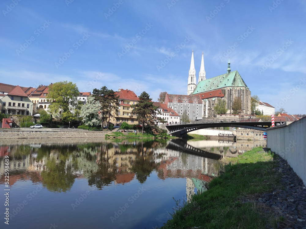 2022-04-29 view of the old town with gothic medieval St. Peter and Paul Church or Peterskirche with two white towers from the side of the river neisse. Goerlitz, Germany