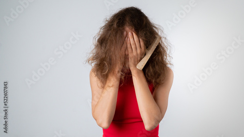 The woman covered her face with her hands - stress due to naughty, brittle and tangled hair