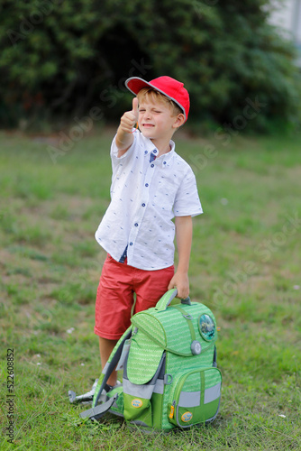 erster schultag - junge mit roter kappe und erhobenem Daumen