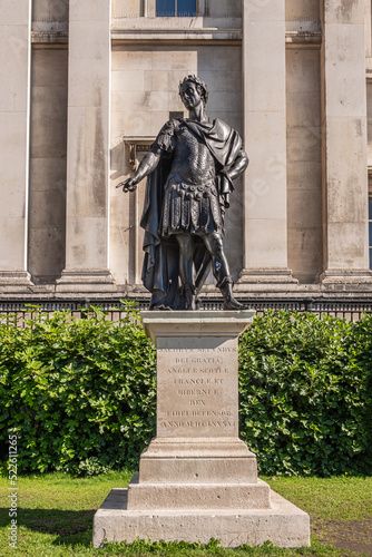 London, UK- July 4, 2022: Trafalgar Square. Closeup of Jacobus Secundus, James II, statue set in front of green hedge and beige National Gallery facade. Image of Roman Emperor. photo