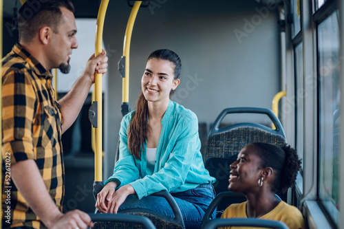 Multiracial group of friends talking while riding in a bus