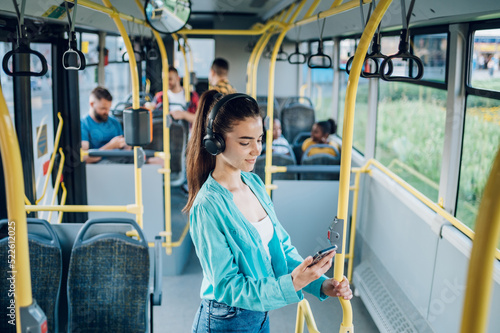 Woman paying a bus ticket via smartphone during a ride