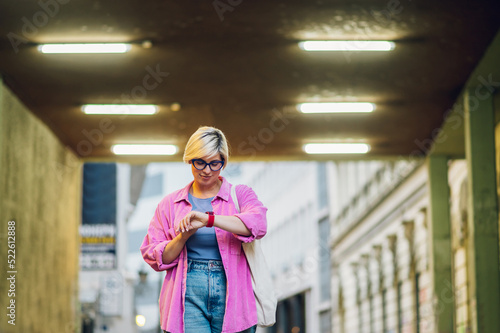 Young plus size woman using smartphone while walking in the city.