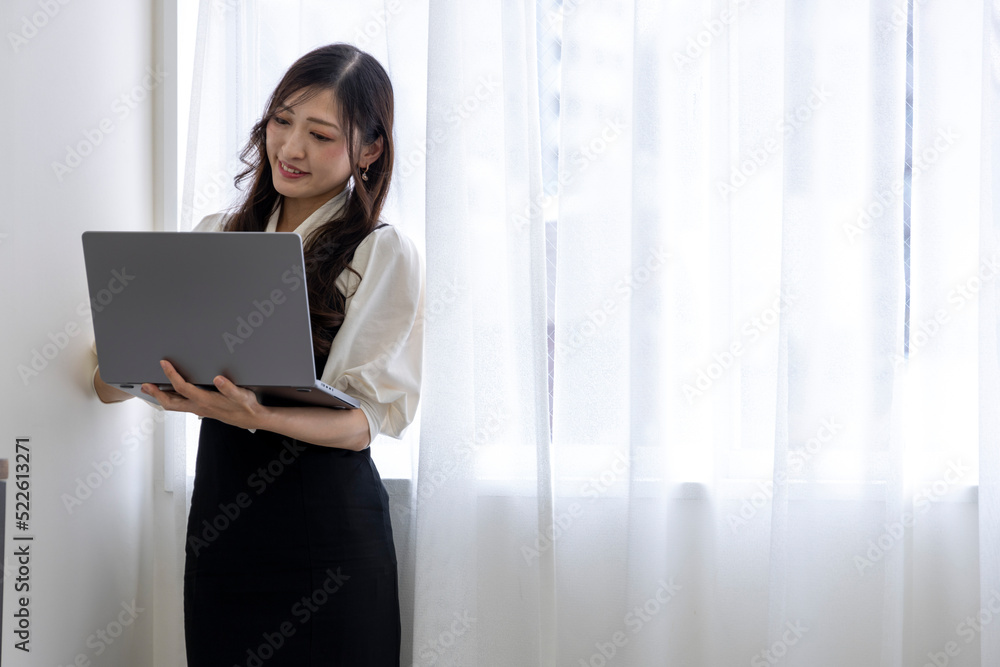 A Japanese woman checking smartphone by remote work in the home office