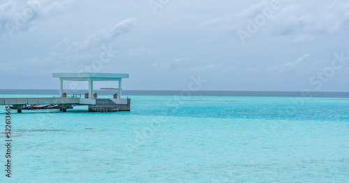 Concrete Pier and dock at tropical beach bay with turquoise water in Maldives Island 2022  © Helder
