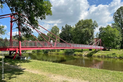 red pedestrian bridge over the river photo