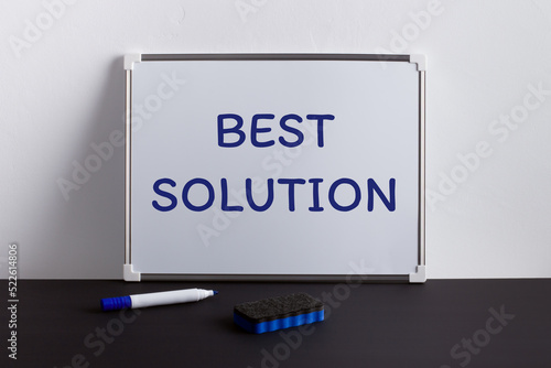 Whiteboard on black table with text BEST SOLUTION. Business concept.