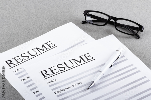 Resume, pen and glasses on the table close-up. Recruitment concept.