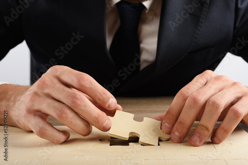 Businessman applies the last part of a missing puzzle