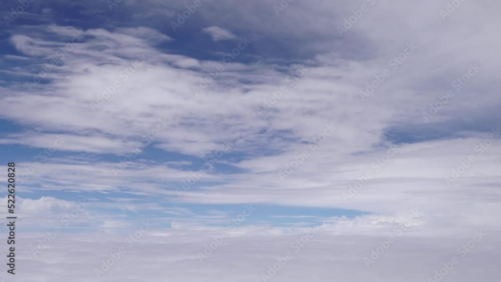 Aerial view from airplane window as it flies between layers of white clouds with blue sky beyond. Aerial view from airplane window as it flies between layers of white clouds with blue sky beyond.