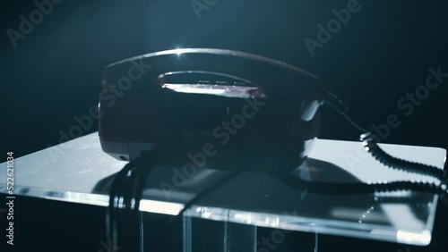 Retro landlines phone at dark room with noir light hand pickup close-up
