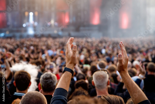 The crowd at a concert. People with raised hands on the dance floor.