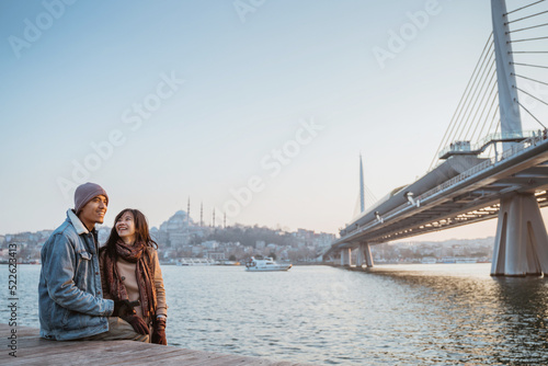 Photography young couple relaxing on the side of bosphorus during sunset