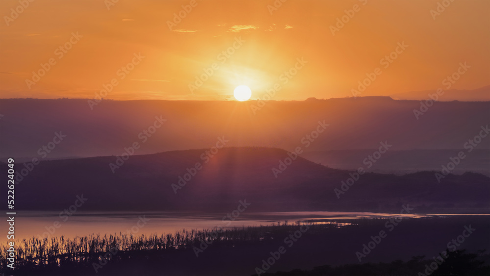 sunrising over mountain with foreground of Lake Nakuru Kenya