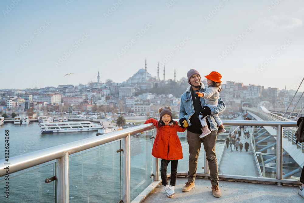 Fototapeta premium father and daughter travel to turkey. portrait of dad and kid enjoying the view of beautiful istanbul turkey from the bridge