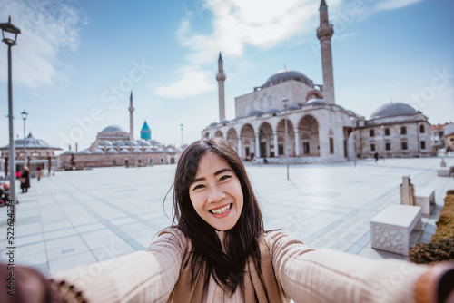 Vászonkép beautiful asian woman taking selfie portrait in front of the mosque in konya tur