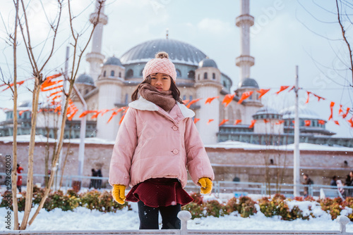 portrait of a girl looking at the camera with mosque in the background