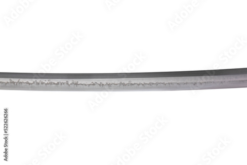 Japanese sword blade (made in China) on white background. Soft focus.  The wavy pattern on the blade edge is a line of hardness that a blacksmith makes so that the blade doesn't break. photo