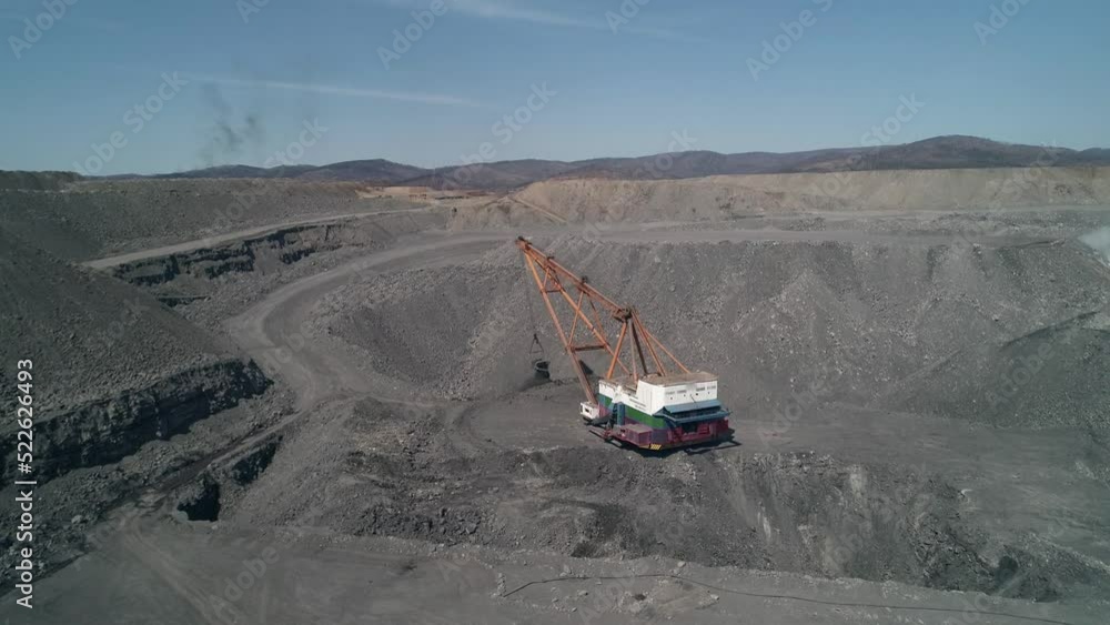 Aerial view to Career walking excavator removes waste rock, digging out layer of useful material. Coal quarry in Russia. Aerial view to Career walking excavator removes waste rock, digging out layer of useful material. Coal quarry in Russia.