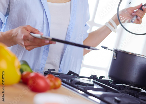 Wallpaper Mural Young woman standing by the stove in the kitchen Torontodigital.ca