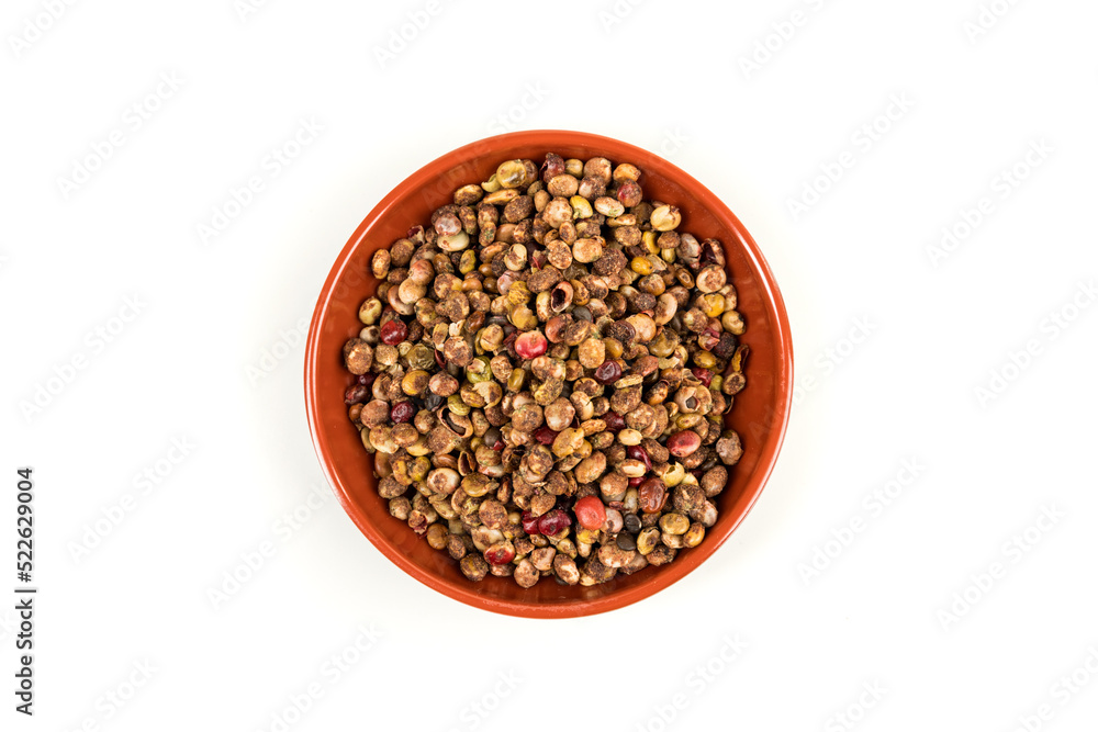 Whole dried sumac berries in a small red and black bowl over white top down Whole dried sumac berries in a small red and black bowl over white top down