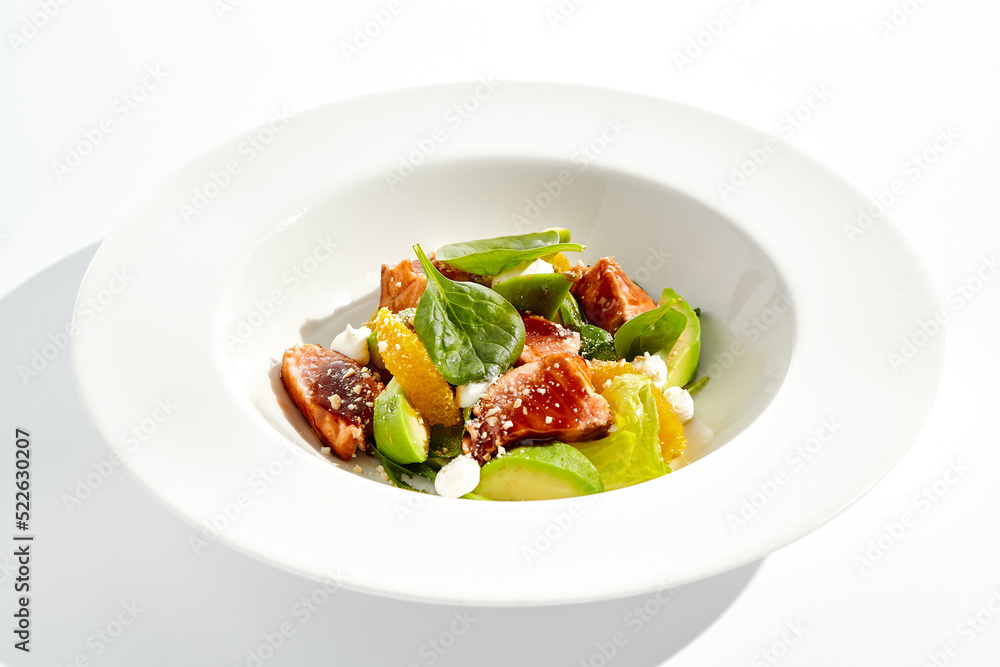 Healthy lunch - green salad with tuna, avocado and orange. Tuna salad for diet. Clean eating in restaurant menu. Grilled Fish with spinach, avocado, citrus isolated on white background. Keto diet. Healthy lunch - green salad with tuna, avocado and orange. Tuna salad for diet. Clean eating in restaurant menu. Grilled Fish with spinach, avocado, citrus isolated on white background. Keto diet.