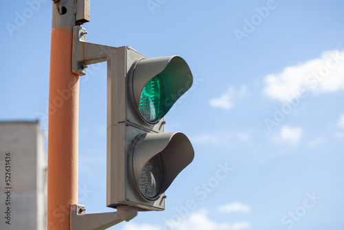 Green light on a pedestrian traffic light against a blue sky. Safe crossing of the road by pedestrians. Place for writing, copy space