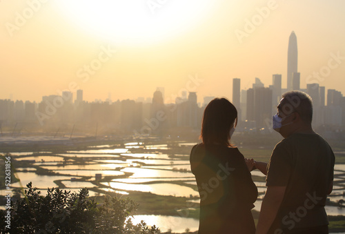 couple watching the sunset with city skyline