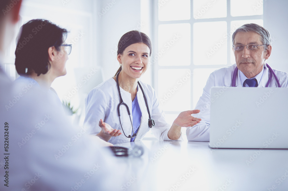 Serious medical team discussing patient's case in a bright office Serious medical team discussing patient's case in a bright office
