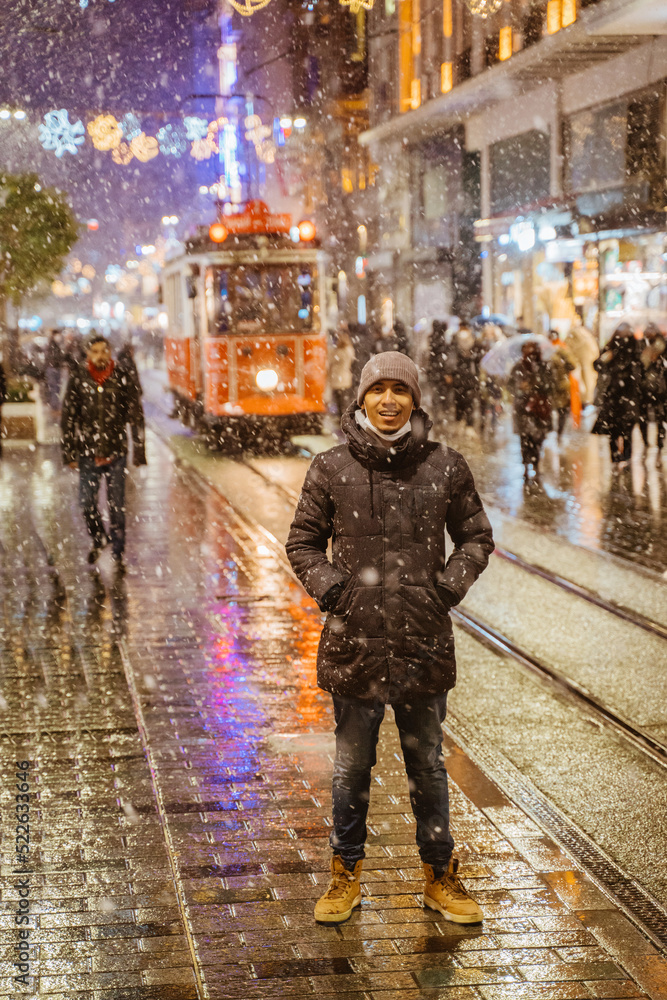 man standing in the middle of the road enjoying snow fall in winter holiday man standing in the middle of the road enjoying snow fall in winter holiday