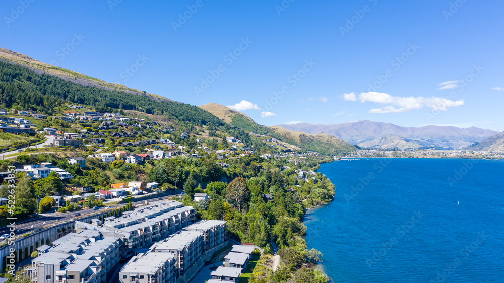 Aerial View from Houses close to the Beach, Lake Wakatipu, Green Trees, Mountains - Queenstown in New Zealand