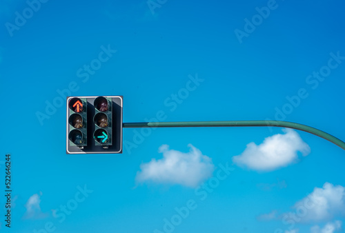 Traffic lights against a vibrant blue sky. Front direction is red, and side direction is green