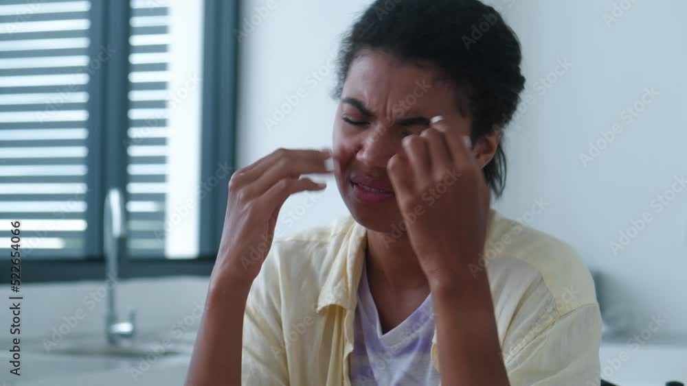 Close up portrait of a young overworked woman massaging her temples, trying to relieve suffering from a terrible headache or migraine due to increased stress of the skull after hard work on a laptop Close up portrait of a young overworked woman massaging her temples, trying to relieve suffering from a terrible headache or migraine due to increased stress of the skull after hard work on a laptop