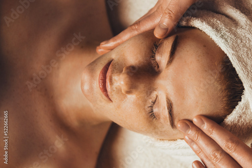 Caucasian freckled woman having a facial massage beauty treatment. Natural woman beauty, skincare. Beauty treatment. Beauty portrait. Healthy lifestyle.