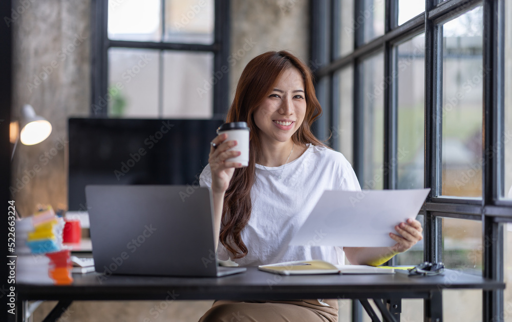 Fototapeta premium Business Asian woman freelancer is working her job on computer laptop from home office Doing accounting analysis report real estate investment data, Financial and tax systems concept.