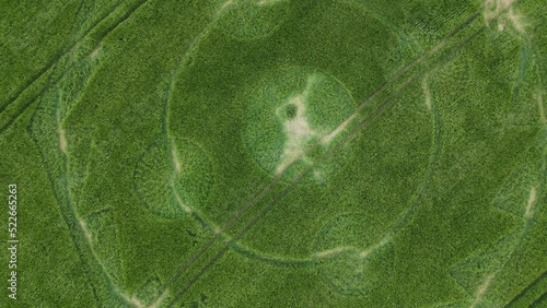 Aerial drone bird's eye shot over a crop circle in a green crop field in Hippenscombe UK at daytime.Rotating shot. photo