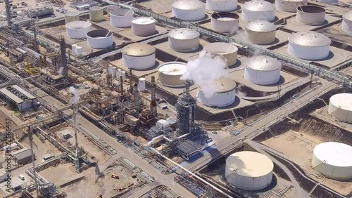 Aerial orbit of a smokestack at an oil refinery during high fuel prices and increased demand
