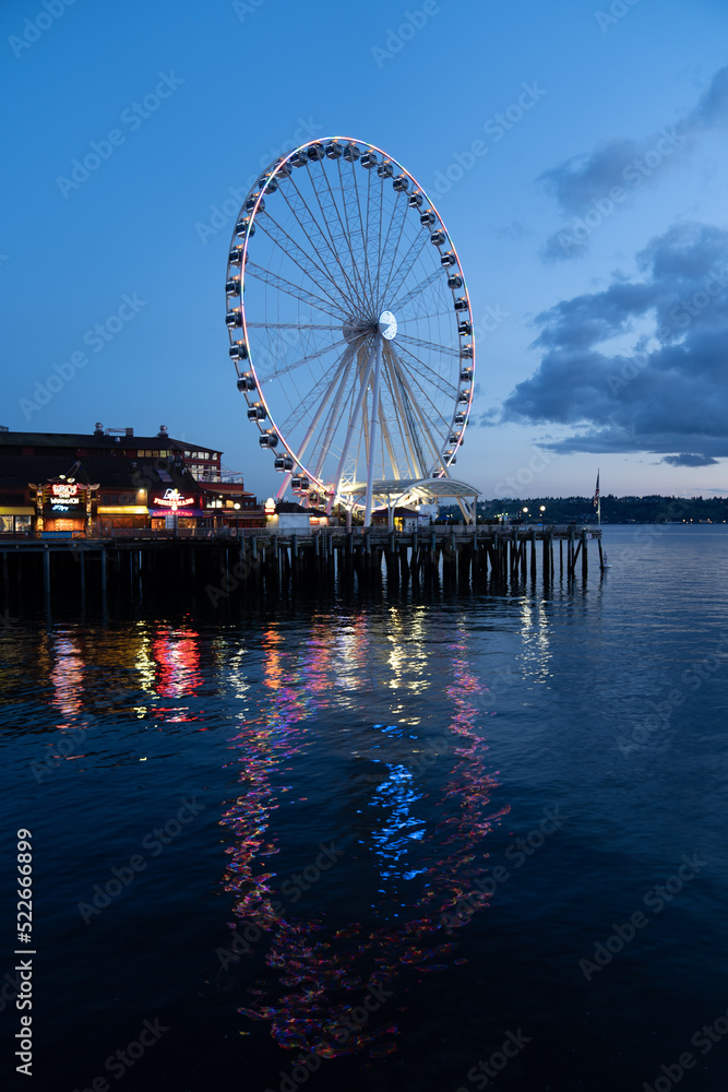 Ferris wheel reflecting in water at night