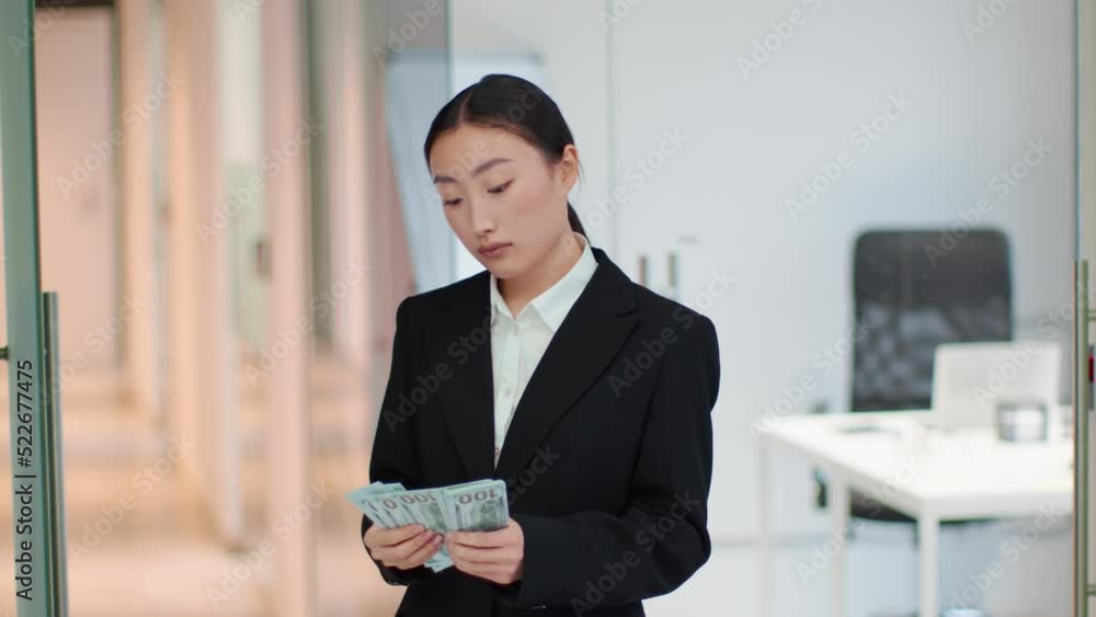 Young asian woman financial consultant counting stack of dollars at office, checking banknotes for fake, free space Young asian woman financial consultant counting stack of dollars at office, checking banknotes for fake, free space