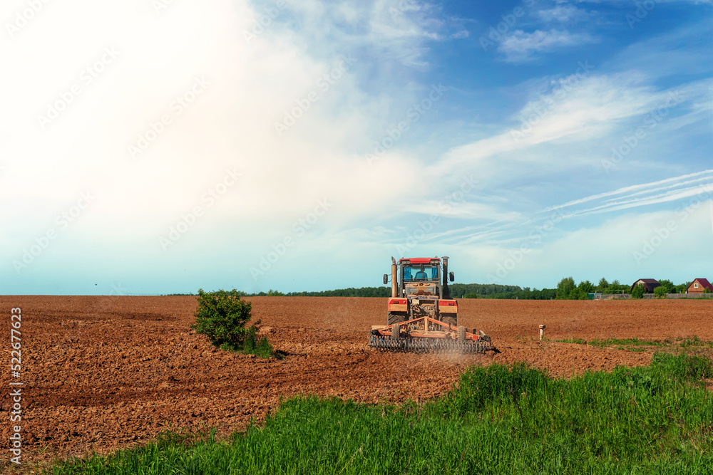 The tractor plows the land. Preparation for sowing and planting. Agriculture image